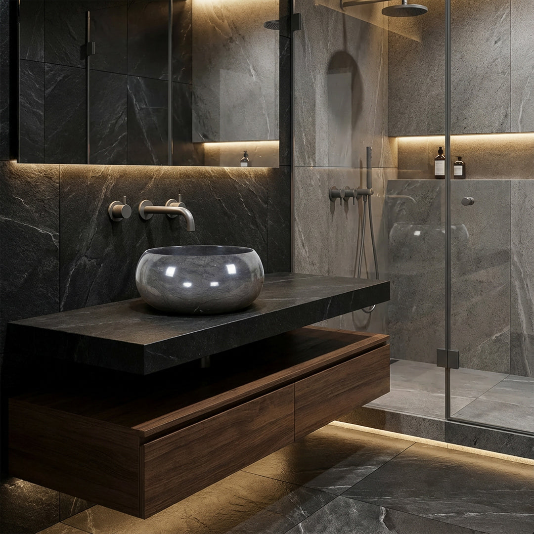 Rund bordplade håndvask af natursten på et mørkt vaskeskab i det moderne spa-badeværelse, kombineret med vægbeslag, glasbruser og indirekte belysning