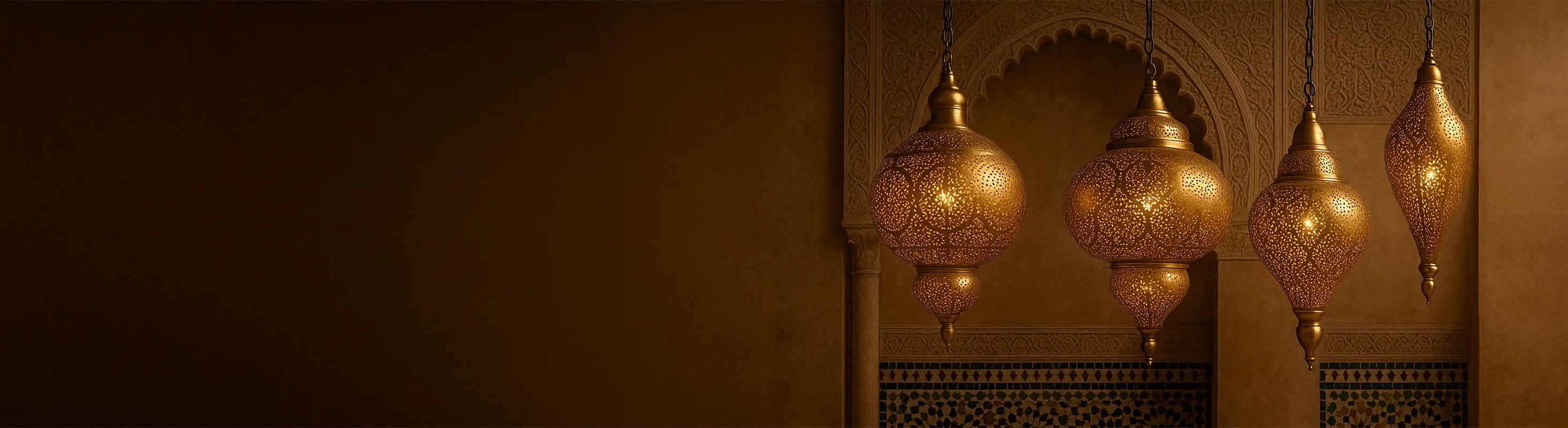 Orientalske loftslamper af messing – Orientalske loftslamper af messing hænger foran udsmykkede buer og mosaikvægge i et marokkansk interiør.