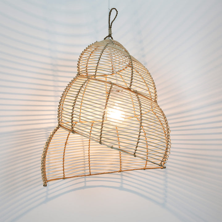 Spiralformet loftslampe i rattan med åben vævning og blødt, naturligt lysspil på væggen