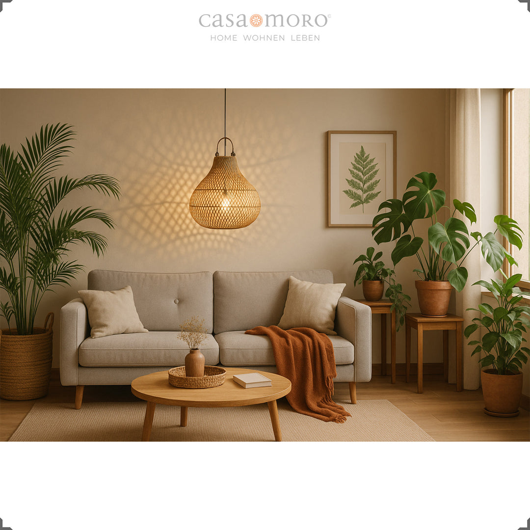 Rattan lampe over sofa i moderne stue med planter og varm lysstemning