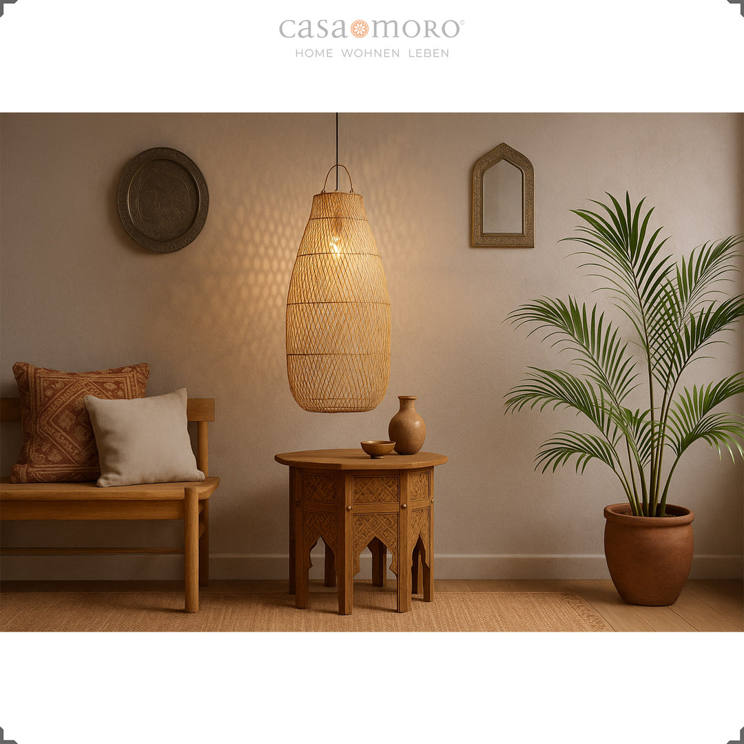 Stor rattan lampe over orientalsk bord i stuen med varmt og naturligt lys