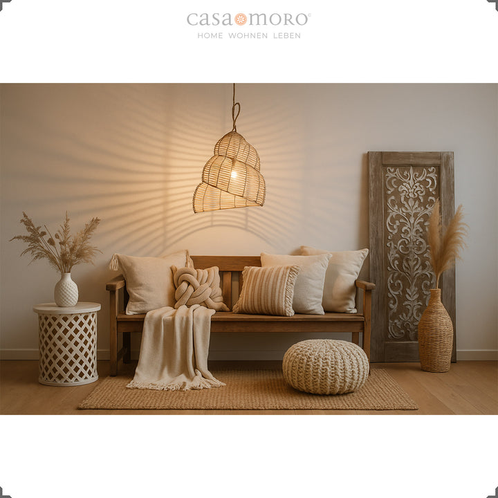 Håndlavet rattanlampe som hængelampe i stuen, med varmt lys og dekorativ boho stil