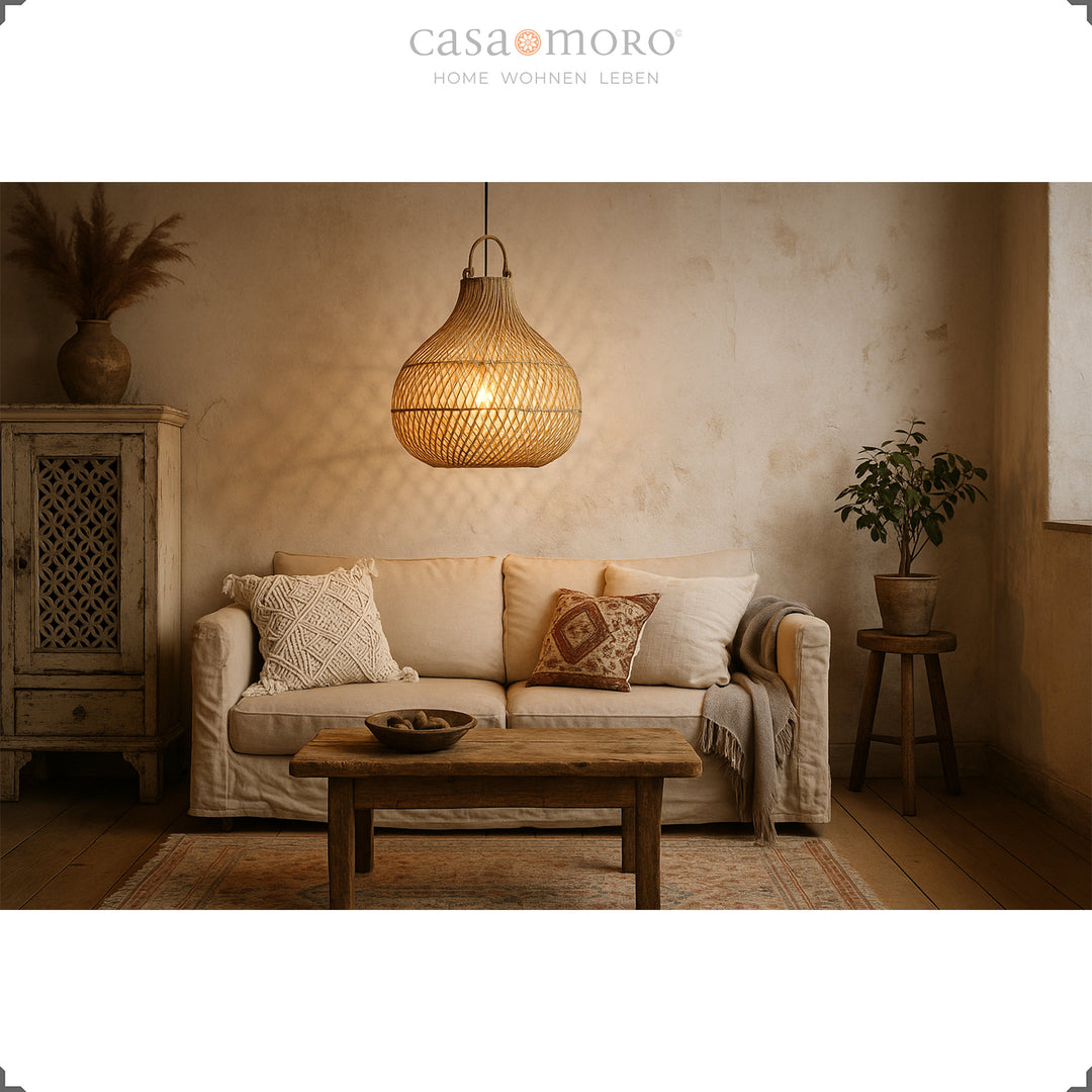 Rattan lampe over sofa i stuen med rustik charme og varmt lysspil